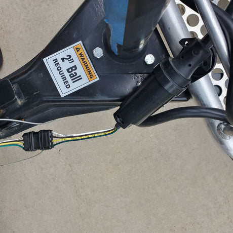 RV rental trailer hitch with "2" Ball REQUIRED" warning and electrical wiring for safe towing.