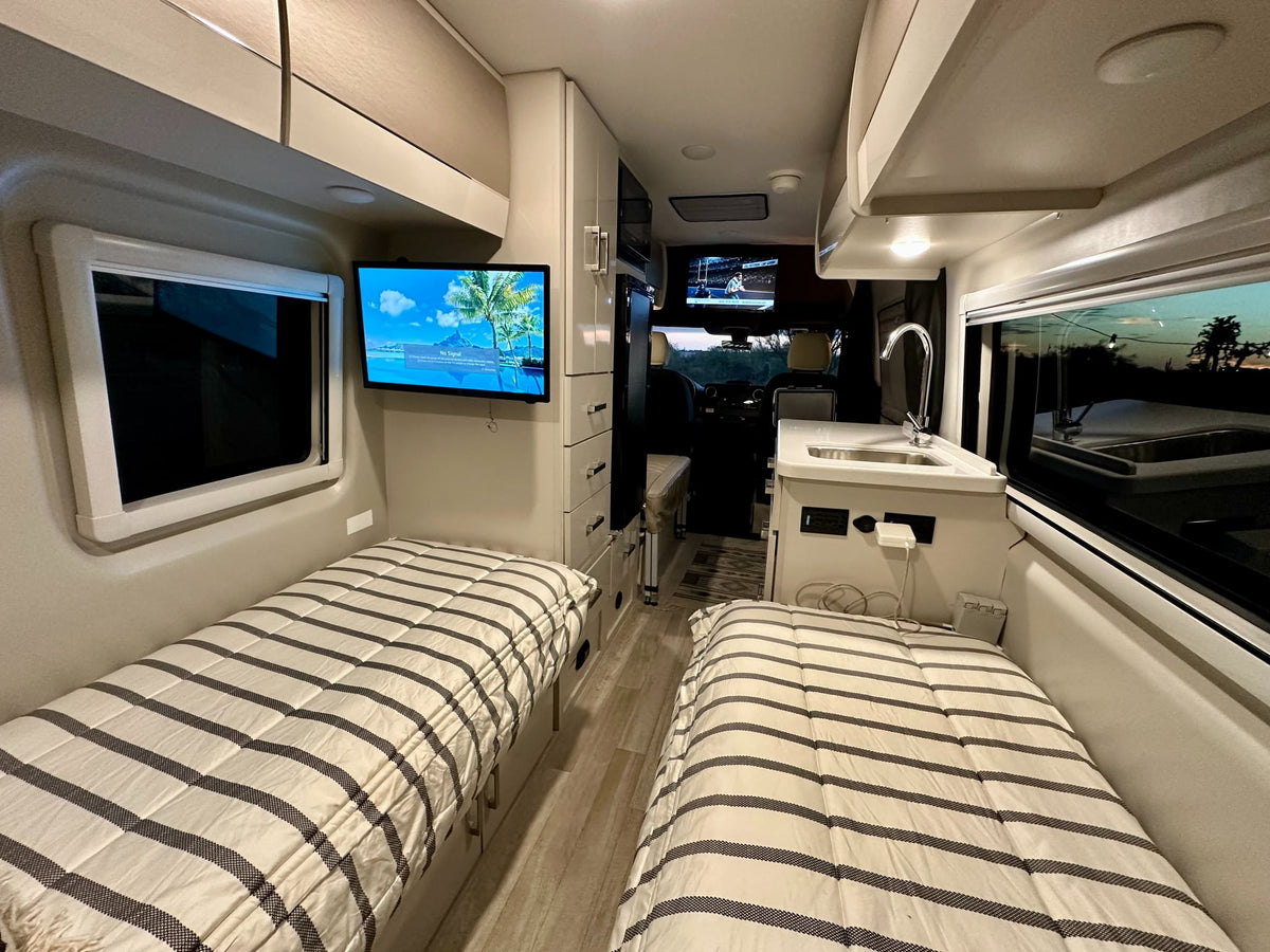  and essential controls. Organized for your travels.|This rv rental's modern interior showcases a kitchen with a sink — photo 10