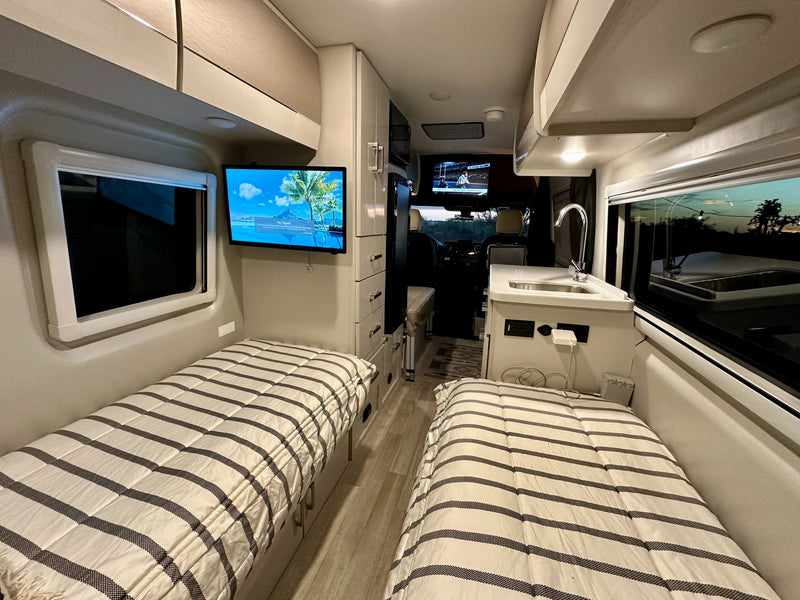 and essential controls. Organized for your travels.|This rv rental's modern interior showcases a kitchen with a sink — photo 10