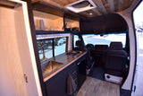 Explore this RV rental's smart interior: a well-equipped kitchen, tiled shower, and front seating area for your journey.