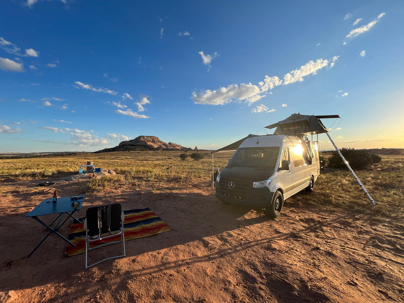 RV rental van with rooftop tent, set up for camping in a scenic desert landscape with mountains. — photo 2