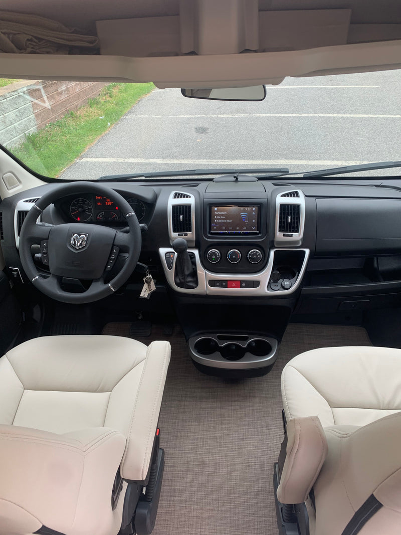 Spacious RV rental cockpit featuring a modern dashboard, steering wheel, and plush captain's chairs. Road trip ready! — photo 9