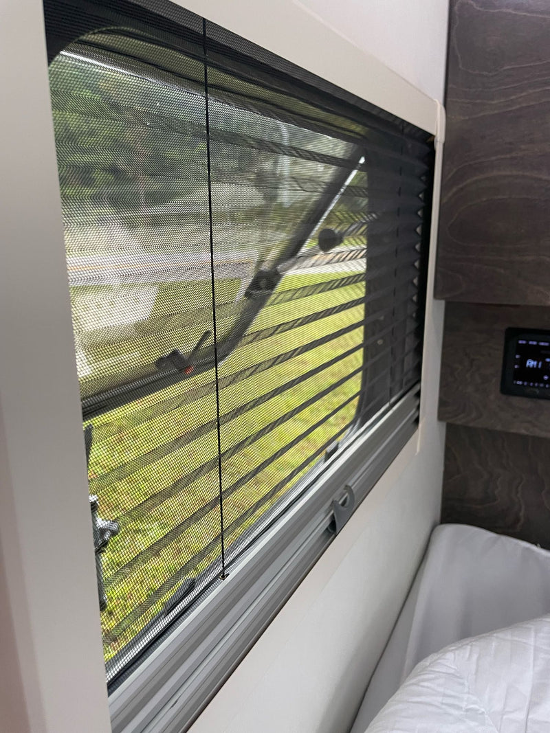  and microwave.|A white teardrop RV rental is set up for camping — photo 7