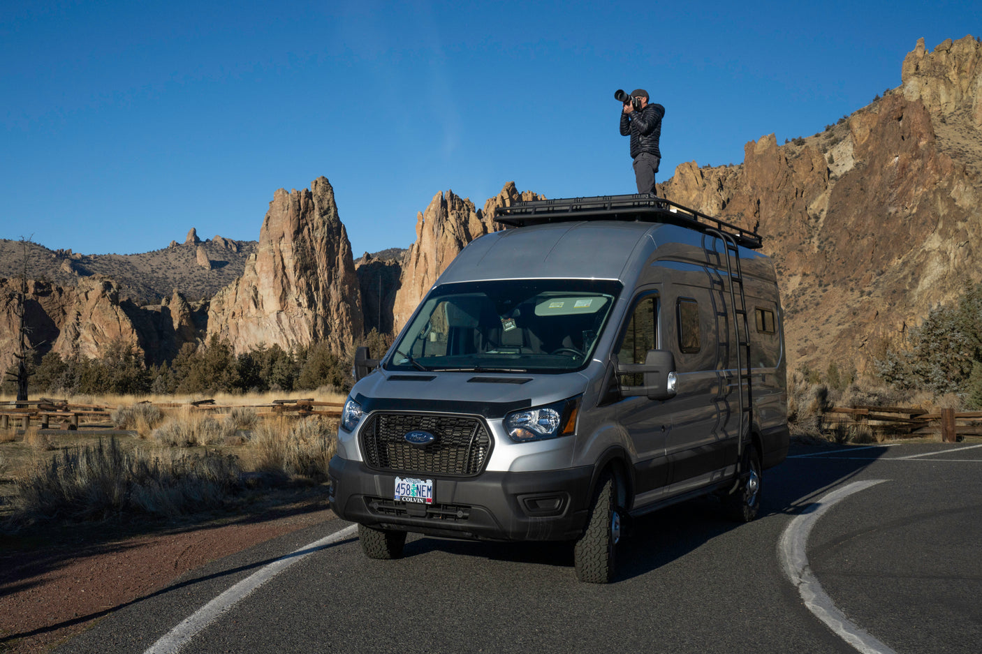 An RV rental provides the perfect vantage for a photographer to capture stunning, rugged landscapes from atop a customized Ford Transit van.