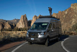 An RV rental provides the perfect vantage for a photographer to capture stunning, rugged landscapes from atop a customized Ford Transit van.
