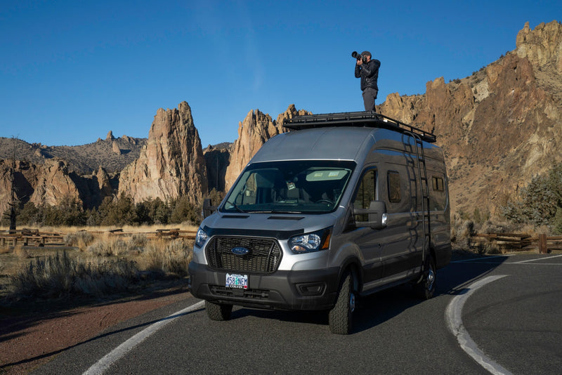 An RV rental provides the perfect vantage for a photographer to capture stunning, rugged landscapes from atop a customized Ford Transit van. — photo 3