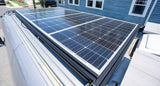 Solar panels installed on a silver van's roof, providing off-grid power for your next RV rental adventure.