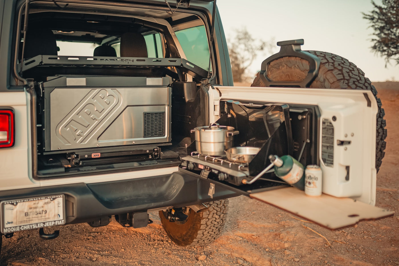 Jeep's rear reveals a portable ARB fridge & tailgate camp kitchen with stove. Ideal for an RV rental outdoor cooking adventure. — photo 2