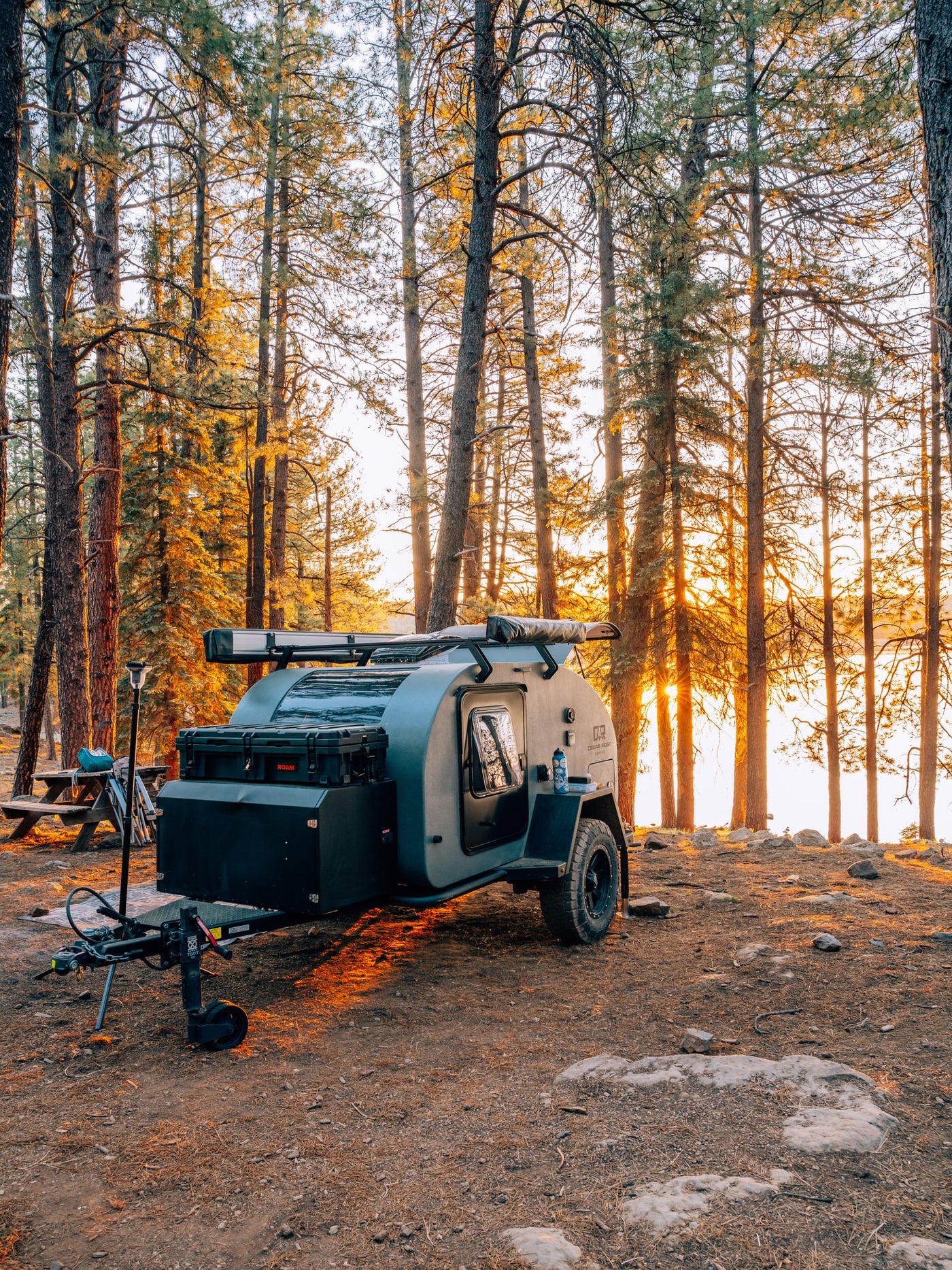 Rugged teardrop RV rental parked in a sun-drenched pine forest at golden hour, perfect for lakeside camping adventures. — photo 14