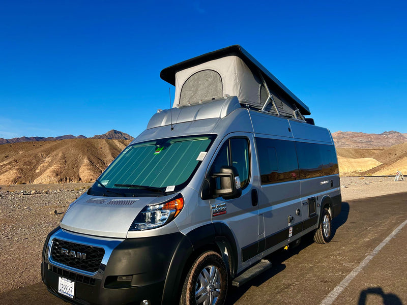 Ready for adventure! This silver pop-top camper van, an ideal rv rental, is parked in a sunny desert landscape. — photo 11