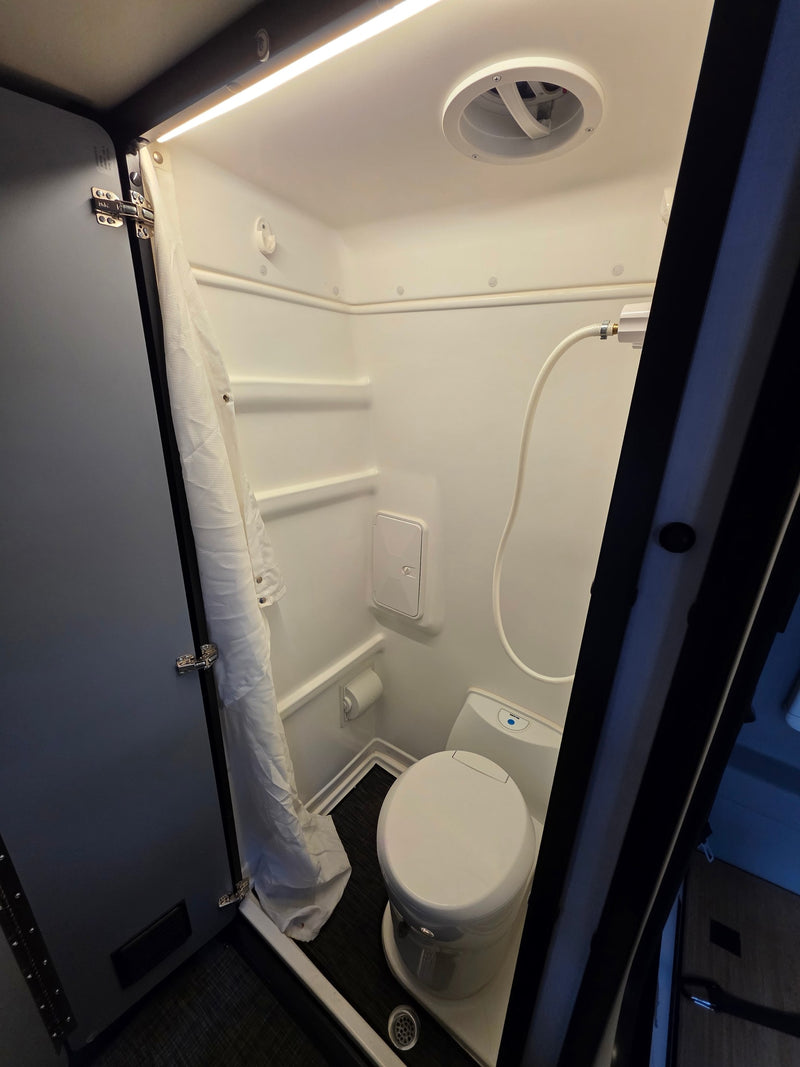Convenient rv rental wet bath with shower, toilet, overhead fan, and LED lighting. Ideal for your travel adventures. — photo 11