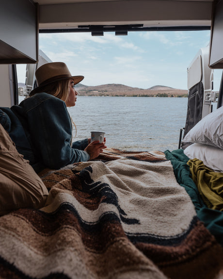 Cozy rv rental interior with open doors to a serene lake.