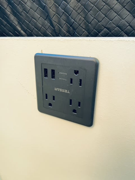 Stay powered up in your **rv rental**! Black TESSAN power strip with multiple AC & USB outlets, flush-mounted for convenience.