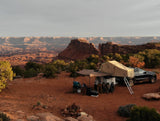 Experience overlanding with this RV rental: a setup featuring an SUV, trailer, & rooftop tents in a vast canyon landscape.