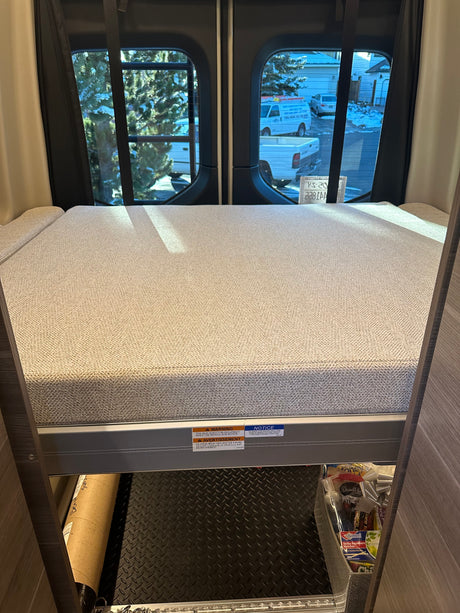 RV rental interior features a cozy bunk bed with under-bed storage, including a diamond plate floor for gear.