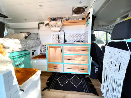 Stylish RV rental interior: bright kitchen, cozy bed, and clever storage solutions for your adventure.