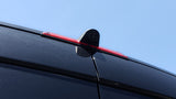 Rearview camera and red third brake light on top of a black RV rental van for safer driving.