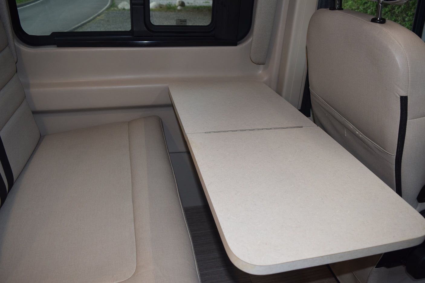 RV rental interior: A light-colored dinette with a folding table and comfortable seating, perfect for travel.