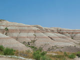 A beautiful landscape of stratified hills with red and white bands under a clear blue sky, ideal for an RV rental trip.