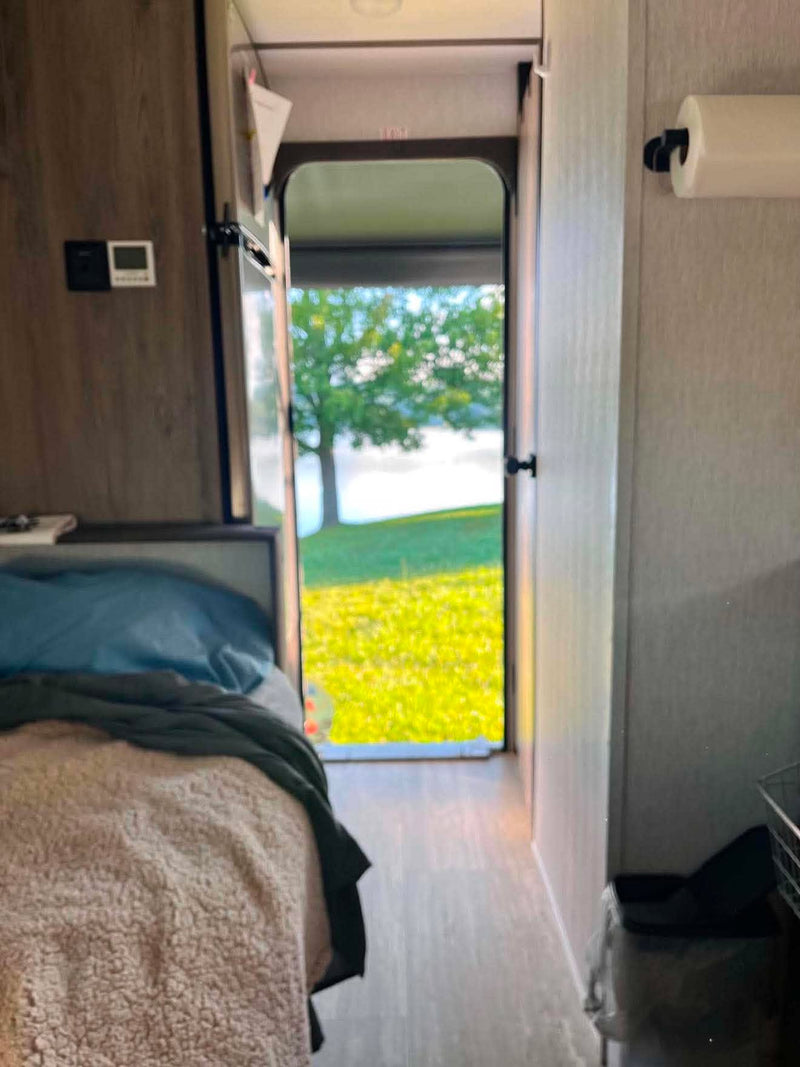  and mirrored cabinet.|RV rental interior showcasing a comfortable main bed — photo 8