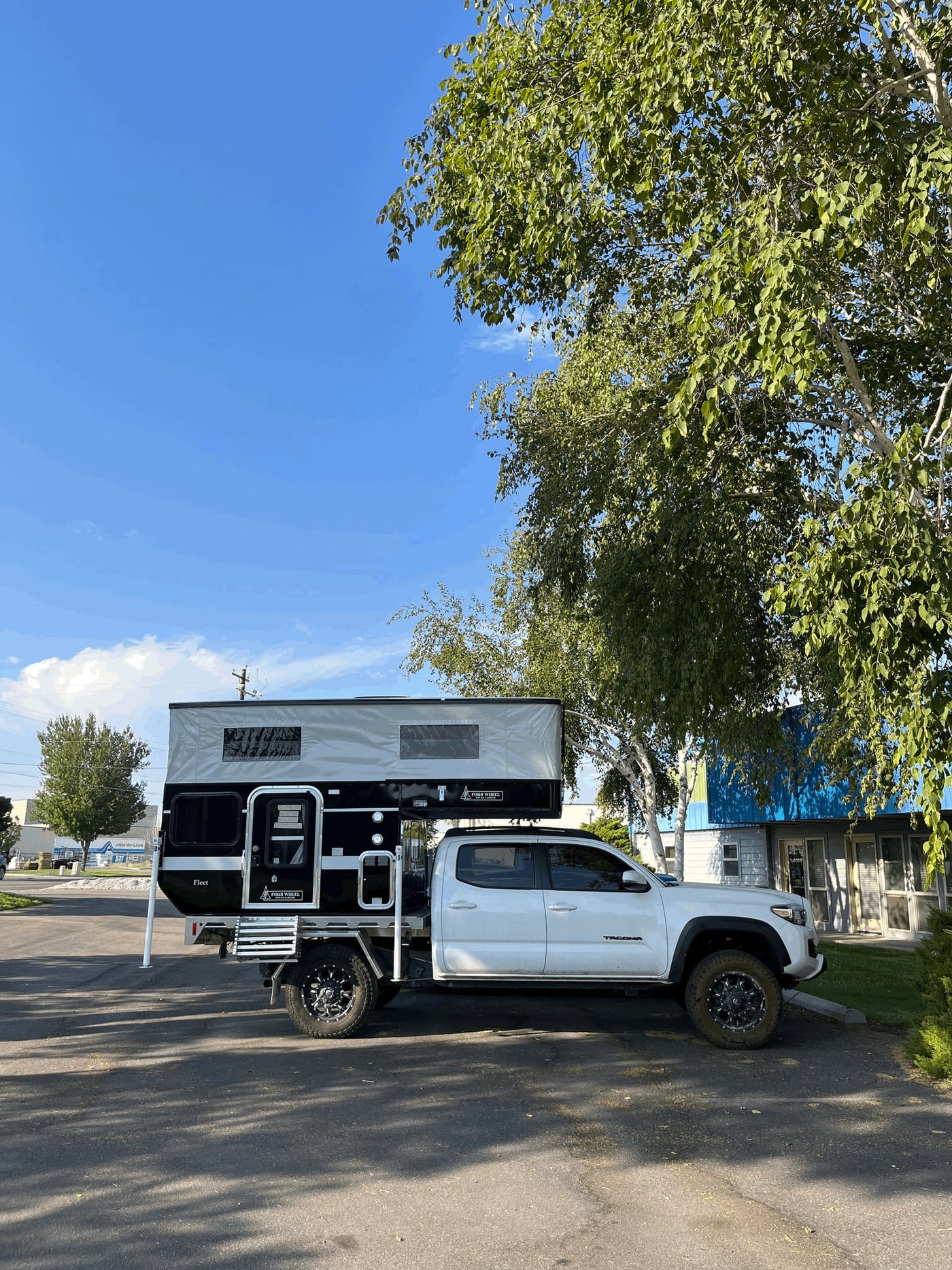  basking in warm light. Perfect for your next RV rental adventure.|A white pickup truck with a black and grey pop-up truck camper — photo 11