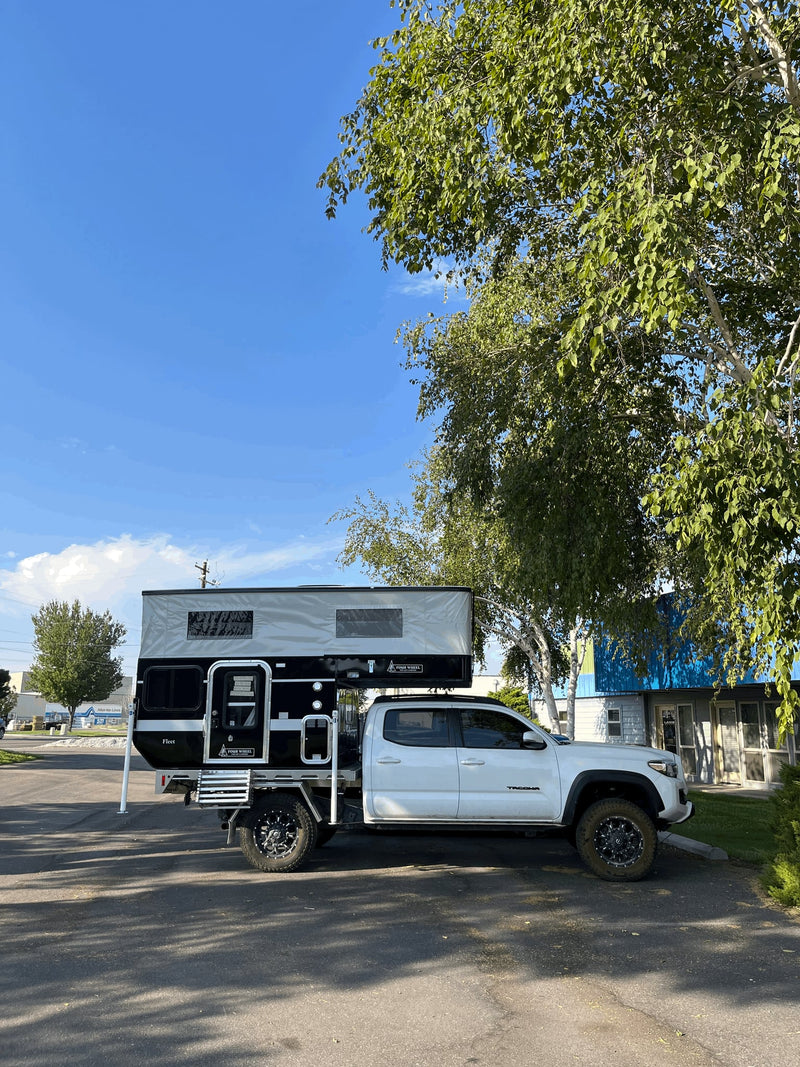  basking in warm light. Perfect for your next RV rental adventure.|A white pickup truck with a black and grey pop-up truck camper — photo 11
