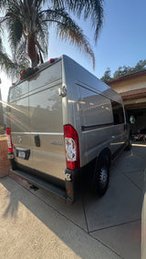 Gray Ram ProMaster camper van, available for RV rental, parked on a sunny driveway.