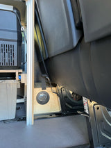 RV rental interior: portable fridge, custom camper van build with an air vent, and passenger seat.