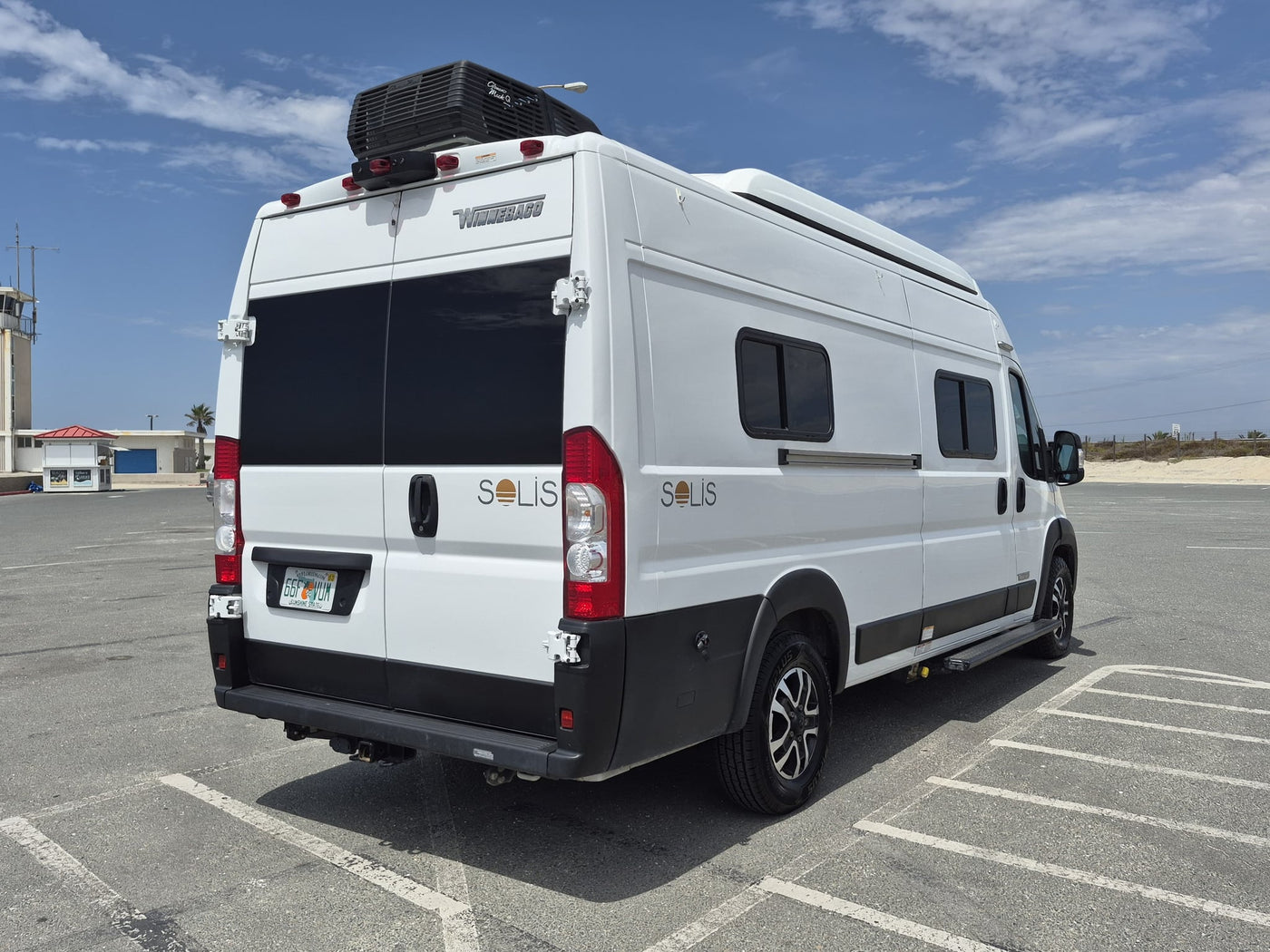  ready for a road trip adventure.|White Winnebago Solis camper van (RV rental) parked in a sunny lot — photo 8