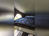Cozy elevated bed in a pop-top RV rental's sleeping area, offering a view outside for your adventure.