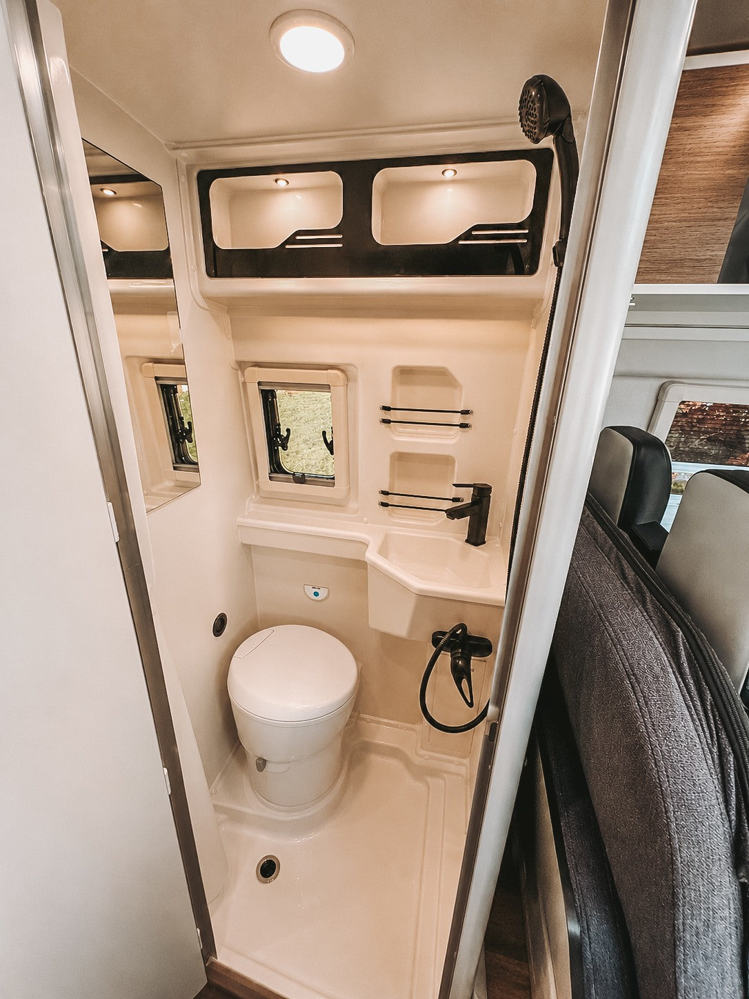 This rv rental features a compact, fully equipped RV bathroom with a toilet, sink, and shower for your journey.