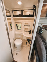 This rv rental features a compact, fully equipped RV bathroom with a toilet, sink, and shower for your journey.