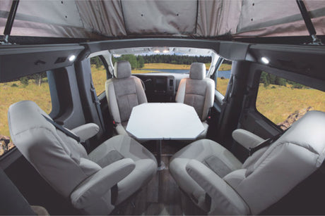  parked on a city street.|A modified silver RV rental