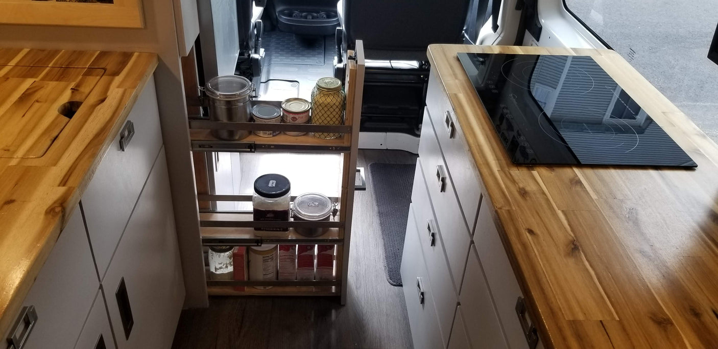 RV rental: Compact kitchen w/ wood counters, cooktop, & clever pull-out pantry for spices & food storage.
