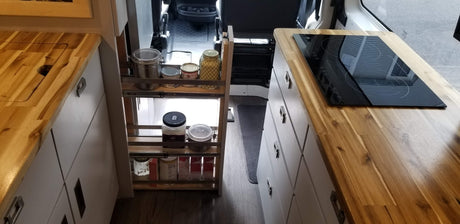 RV rental: Compact kitchen w/ wood counters, cooktop, & clever pull-out pantry for spices & food storage.