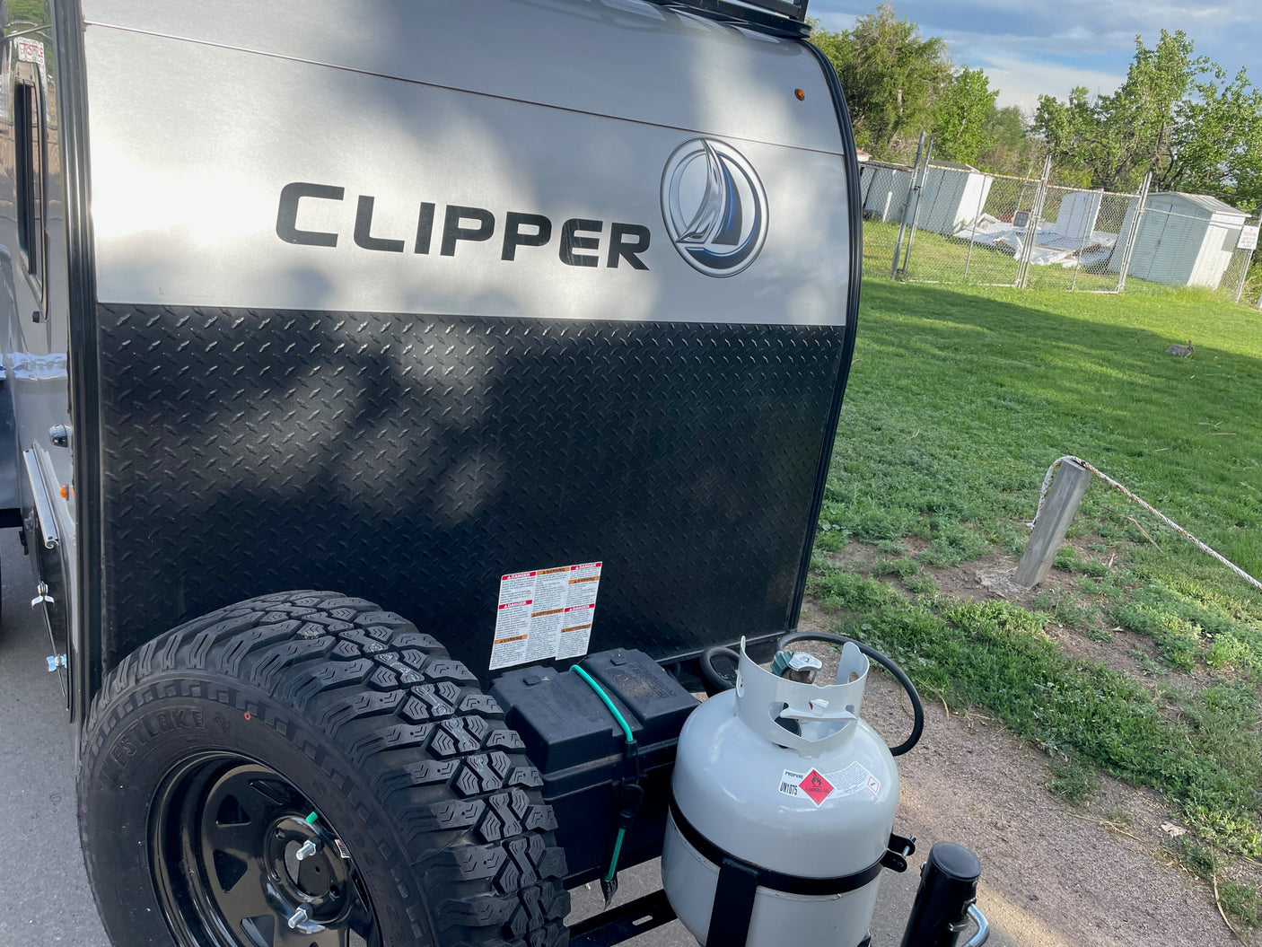 Front of a Clipper RV rental, featuring its spare tire, propane tank, and power system. Perfect for outdoor adventures.