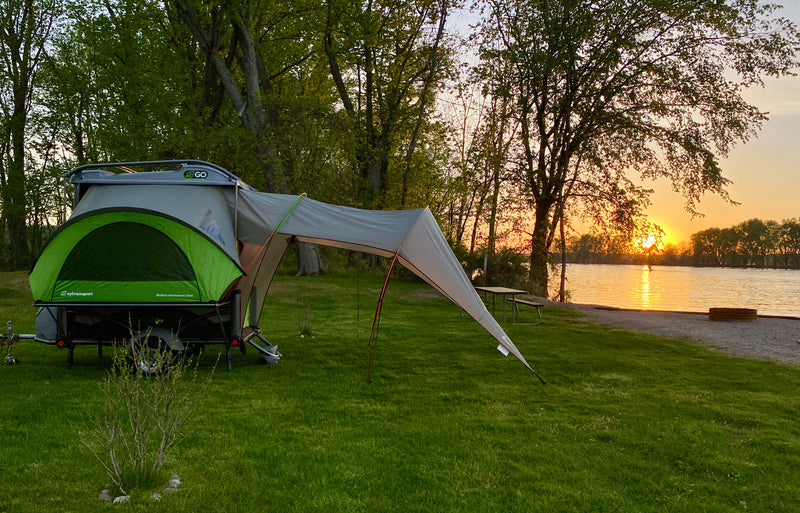 Experience serene sunset camping with this SylvanSport Go RV rental, a versatile pop-up trailer beside a tranquil lake. — photo 5