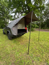  parked on grass. A unique RV rental option for outdoor adventure.|Innovative Cybertruck camping setup