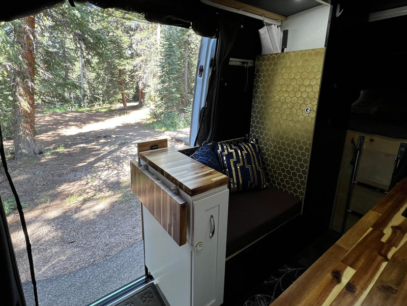  wooded campsite. Perfect for nature road trips & adventure.|RV rental camper van interior. Cozy space with a pull-out counter — photo 3