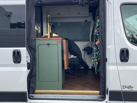 Explore this cozy RV rental campervan featuring a stylish mobile kitchen, wood floor, and custom interior for your next adventure.