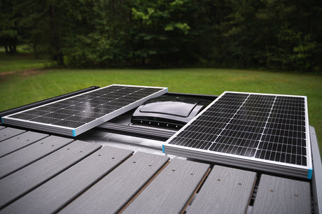 RV rental rooftop with two solar panels and a central vent, providing off-grid power.