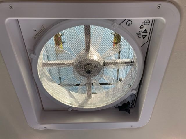 Close-up of a Maxxair ceiling vent fan inside an rv rental, showing controls and mesh screen. Great for air circulation.