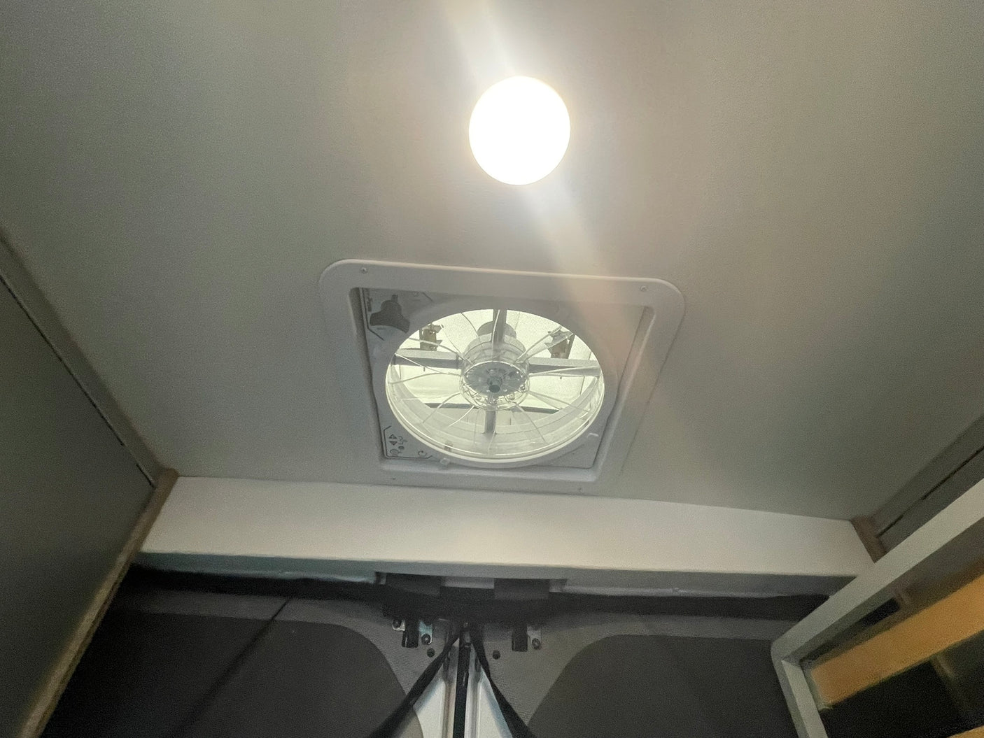 Interior of an rv rental showing a bright ceiling light and a functional roof vent fan, indicating comfort features.