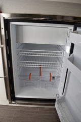 Inside an RV rental compact refrigerator: wire shelves, top freezer, and crisper bins, spotless and ready.