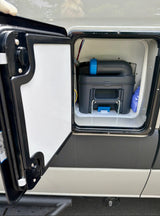 rv rental: View into an open external RV compartment, revealing a removable cassette toilet system for waste disposal.