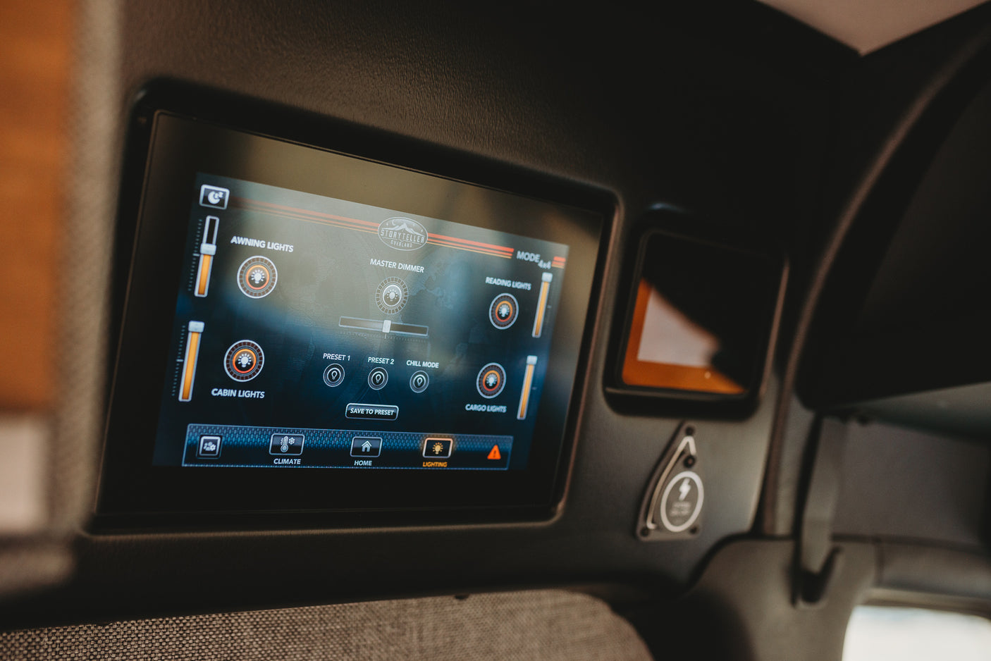 A Storyteller Overland RV rental's digital control panel manages cabin, awning, and cargo lighting with dimmer and preset options.