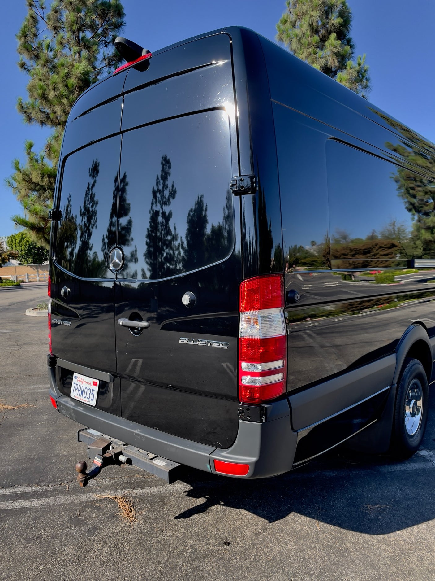 Rear view of a shiny black Mercedes-Benz Sprinter van with a U-Haul hitch. Perfect for an RV rental. CA plate 7PHW035.