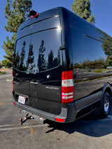 Rear view of a shiny black Mercedes-Benz Sprinter van with a U-Haul hitch. Perfect for an RV rental. CA plate 7PHW035.