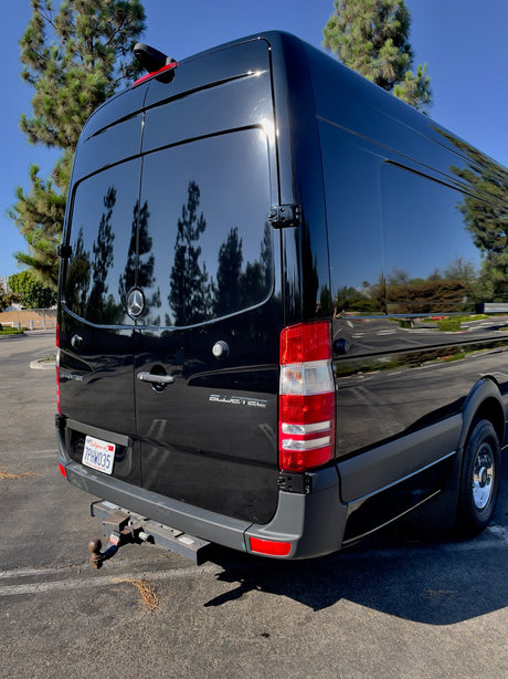 Rear view of a shiny black Mercedes-Benz Sprinter van with a U-Haul hitch. Perfect for an RV rental. CA plate 7PHW035.