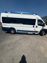 Side view of a white & blue Zion Slumber camper van, ideal for an RV rental road trip adventure.
